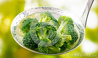 Ladle full of steamed fresh young broccoli florets Stock Photo