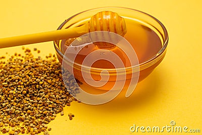 A ladle of honey on the background of a honeycomb of a bee. Honey tidbit in a glass jar honey spoon, bee bread and a Stock Photo