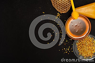 A ladle of honey on the background of a honeycomb of a bee. Honey tidbit in a glass jar honey spoon, bee bread and a Stock Photo