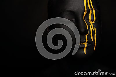 Lady in black paint with yellow smudges Stock Photo