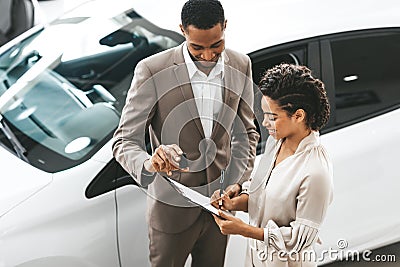 Lady Buying Car Signing Papers With Dealer In Dealership Store Stock Photo