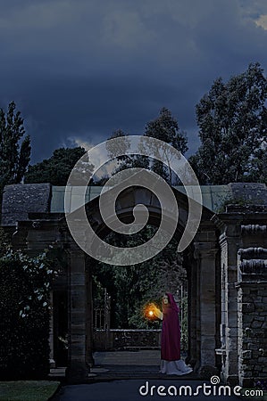 Lady in castle garden at night Stock Photo