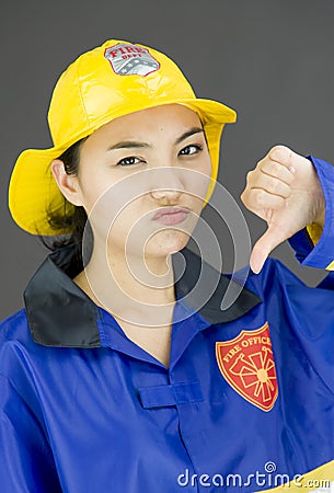 Lady firefighter showing thumbs down sign Stock Photo