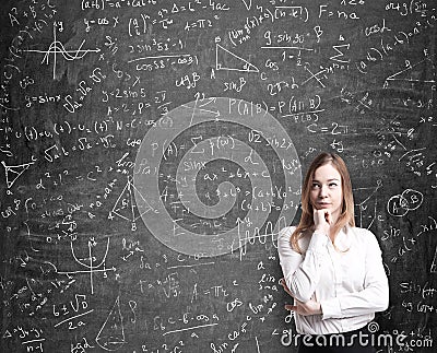 Lady in formal clothes thinking about possible solutions of the quantitative problems. Math formulas are drawn on the bl Stock Photo