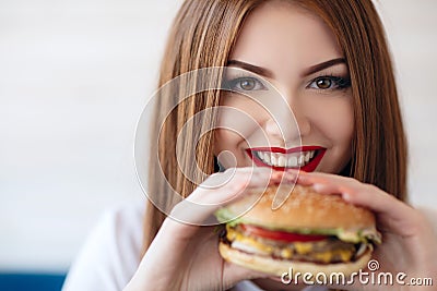 Lady with a hamburger for a table in a cafe Stock Photo