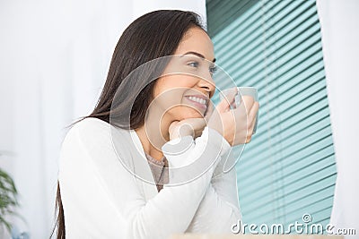 lady having cuppa and looking out throught he window Stock Photo