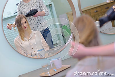 Lady having hair dried in hairdressers Stock Photo