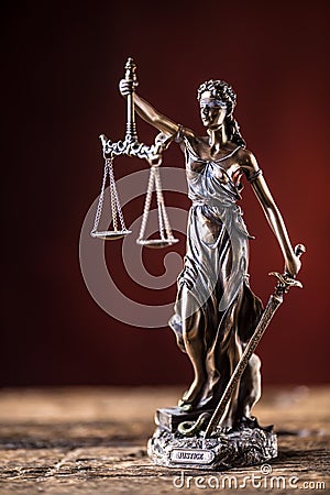 Lady Justicia holding sword and scale bronze figurine on wooden Stock Photo