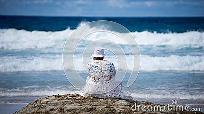 Lady Looking At The Beach Waves Reminiscing Stock Photo