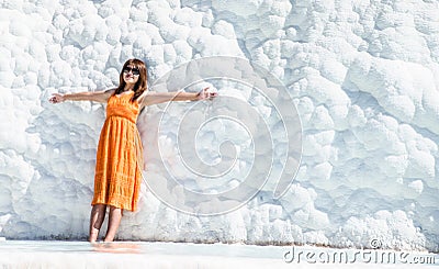Lady in orange dress posing for photo at Pamukalle n Turkey with wide spread hands Editorial Stock Photo
