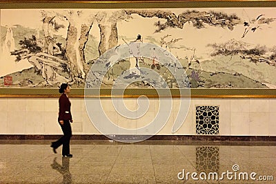 A lady passing by a Chinese painting in the Great Hall of People in Beijing Editorial Stock Photo