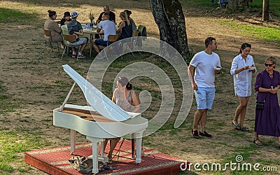 Lady playing white piano, village charity event Editorial Stock Photo