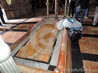 Lady praying at the Stone of Anointing at Church of the Holy Sepulchre, Jerusalem Editorial Stock Photo