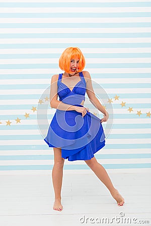 Lady red or ginger wig posing in blue dress. Comic and humorous concept. Woman playful mood having fun. Fun and Stock Photo