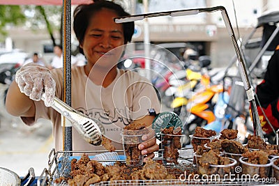 A lady sells deep fried pork liver in her street food cart Editorial Stock Photo