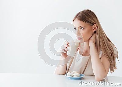 Lady sitting isolated near sweeties drinking coffee Stock Photo
