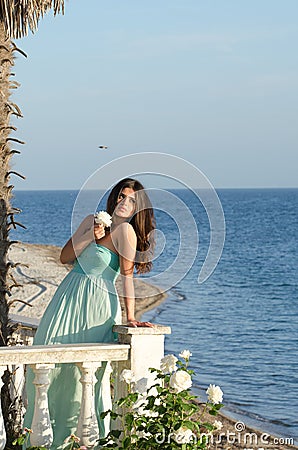 Lady standing on veranda of a beachfront home Stock Photo