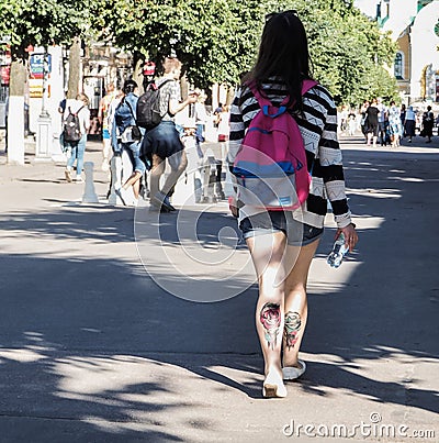 Lady with a tattoo on the calf is in the summer the city centre. Rear view. City life. Saint-Petersburg. The summer of 2017. Editorial Stock Photo