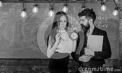 Lady teacher and strict schoolmaster care about discipline and rules in school. Man with beard hold book and girl Stock Photo