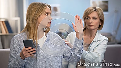 Lady trying to improve family relations and daughter showing stop sign, problem Stock Photo