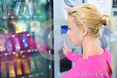 Lady using a modern vending machine Stock Photo