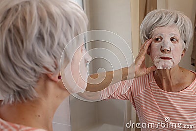 Lady using a nourishing tissue face mask Stock Photo