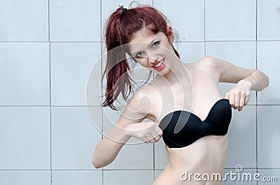 Lady wear lingerie standing against tile wall Stock Photo