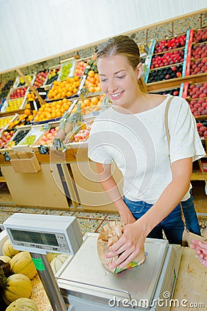 Lady weighing produce in paper bag Stock Photo