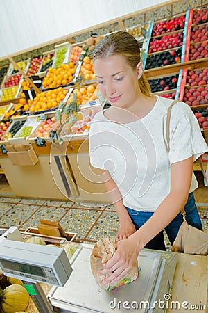 Lady weighing produce in paper bag Stock Photo