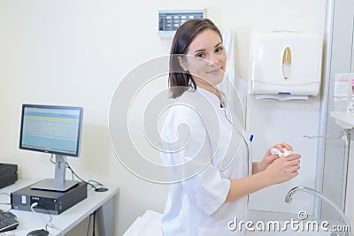 Lady in white coat washing hands Stock Photo