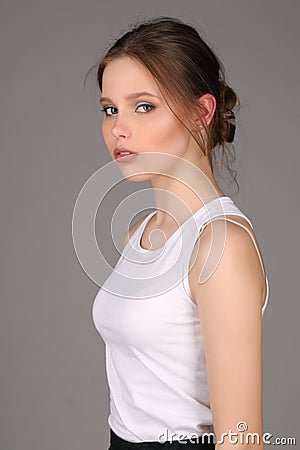 Lady in white singlet standing profile. Close up. Gray background Stock Photo
