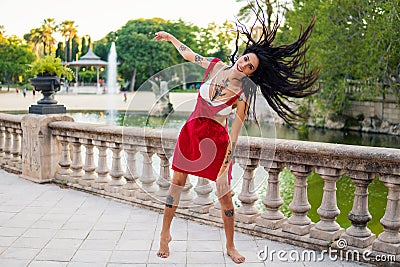 Ladyboy tattooed transgender model is dancing in the green park Stock Photo