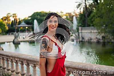 Ladyboy tattooed transgender model is dancing in the green park Stock Photo