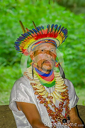 LAGO AGRIO, ECUADOR - NOVEMBER 17, 2016: Close up of a Siona shaman in traditional dress with a feather hat in an Editorial Stock Photo