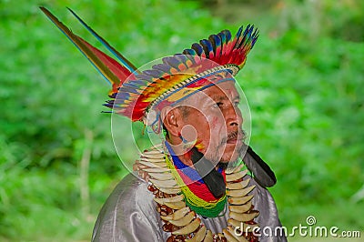 LAGO AGRIO, ECUADOR - NOVEMBER 17, 2016: Close up of a Siona shaman in traditional dress with a feather hat in an Editorial Stock Photo