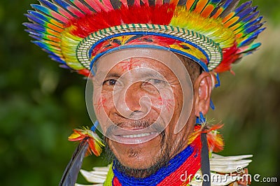 LAGO AGRIO, ECUADOR - NOVEMBER 17, 2016: Portrait of a Siona shaman in traditional dress with a feather hat in an Editorial Stock Photo