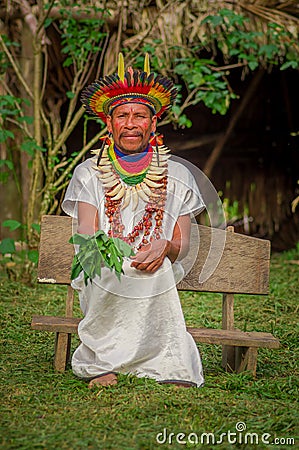 LAGO AGRIO, ECUADOR - NOVEMBER 17, 2016: Siona shaman in traditional dress with a feather hat in an indigenous village Editorial Stock Photo