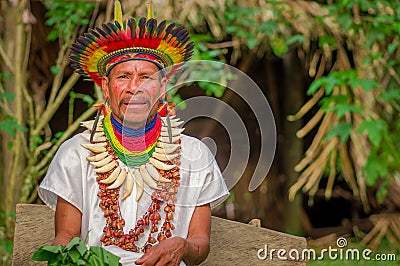 LAGO AGRIO, ECUADOR - NOVEMBER 17, 2016: Siona shaman in traditional dress with a feather hat in an indigenous village Editorial Stock Photo