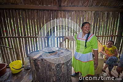 LAGO AGRIO, ECUADOR - NOVEMBER, 17 2016: Woman demonstrates cooking yucca tortillas in an indoors kitchen in a Siona Editorial Stock Photo