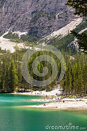 Lago Di Braies, Italy - June 1, 2018: View on the crystal clear lake with people on beach Editorial Stock Photo