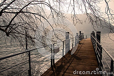 Lago di Como, Italy. Pespective view of a ferry pier at sunset. Winter landscape. Stock Photo