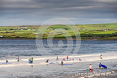 Lahinch / Ireland 08/06/2020: Beach full of surfers of all age on a warm sunny day. Cloudy sky Editorial Stock Photo
