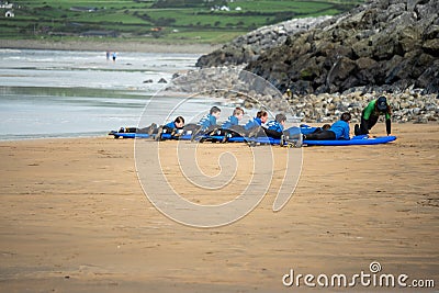 Lahinch / Ireland 08/06/2020: Couch teaches a group young boys surfing on a beach, kids dressed in wet suits Editorial Stock Photo