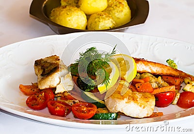 Laid table in a restaurant with fish and fresh vegatables Stock Photo