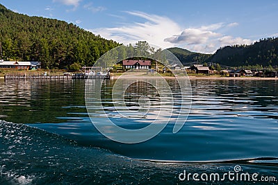 Lake Baykal near green forest mountain and wooden house Stock Photo
