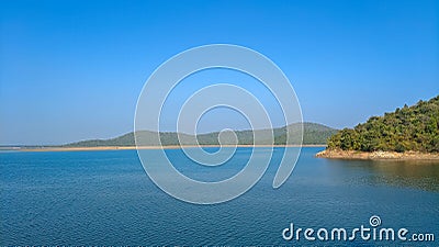 Lake with clear blue sky and green forest background, summer scene Stock Photo
