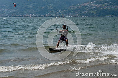 Lake Como, Italy - July 21, 2019. Water sport: kitesurfer riding on a bright sunny summer day near the Colico, town in Italy. Alp Editorial Stock Photo
