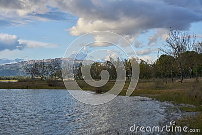 Lake dam landscape with reflection of Gardunha mountains and trees on a cloudy day in Santa Agueda Marateca Dam in Portugal Stock Photo