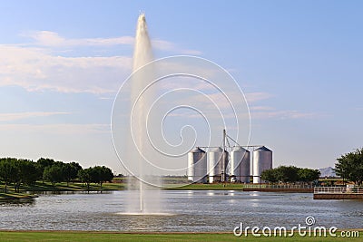 Lake with Fountain and Silos in the Background Stock Photo