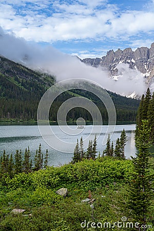 Lake Josephine in Glacier National Park as a boat passes by Stock Photo
